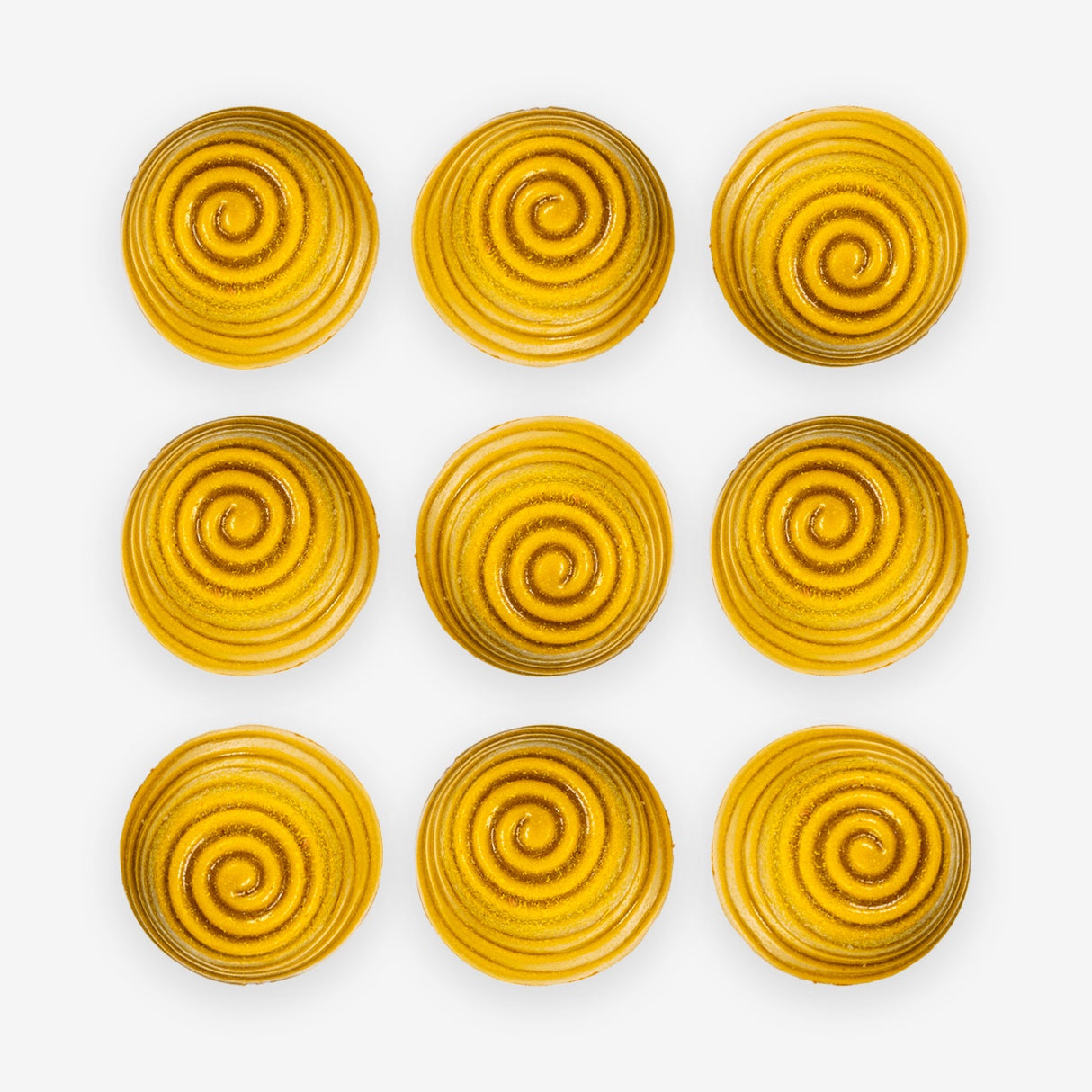 Nine yellow spiral-patterned Manuka honey chocolates arranged in a 3x3 grid on a white background.