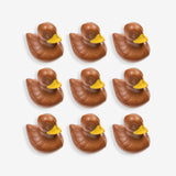 Nine chocolate ducks with yellow beaks arranged in a 3x3 grid on a white background.